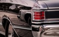 Rear Part Of Exterior Of A Black Old Timer Luxury Sports Car With Tail Lights In Chrome Frames And Shiny Chrome Bumper