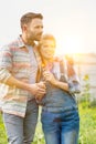 Rear photo of a loving husband and wife farmers looking locing over their beautiful farm