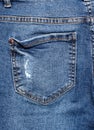 Rear pocket of torn worn jeans.