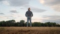 Rear shot of the farmer in the field looking at the cloudy sky