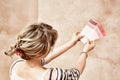 Rear view of woman holding paint color swatches in unrenovated room Royalty Free Stock Photo