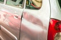 Rear side of broken and damaged silver car wreck in crash accident with scratched paint in collision close up, selective focus Royalty Free Stock Photo