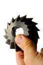 Single angle milling cutter with securing groove on internal diameter, slightly used, held in left hand on white background