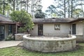 Rear side view of brown spanish style stucco and cinder block 1970's house with a stone circular patio Royalty Free Stock Photo