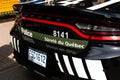 Rear of SuretÃ© du QuÃ©bec national police force parked black car with small rainbow heart sticker