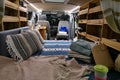 Rear to front view of customized natural wooden interior of a camper van,