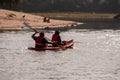 Rear of two people kayaking in a sunlit river