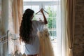 Rear viev bride in lingerie in the morning before the wedding. White negligee of the bride, preparing for the wedding