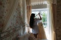 Rear viev bride in lingerie in the morning before the wedding. White negligee of the bride, preparing for the wedding Royalty Free Stock Photo