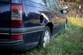 Rear view of an abandoned dark blue station wagon car Royalty Free Stock Photo