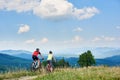 Rear view of active couple bikers in professional sportswear riding cross country bicycles down Royalty Free Stock Photo