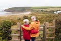 Rear View Of Active Senior Couple Looking Out Over Gate As They Walk Along Coastal Path In Fall Royalty Free Stock Photo