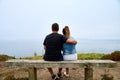 Rear view of an adult couple sitting on a beachside bench Royalty Free Stock Photo