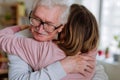 Rear view of adult daughter hugging her senior father when visitng him at home. Royalty Free Stock Photo