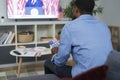 Rear view of  affectionate man watching USA election on TV Royalty Free Stock Photo