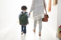 Girl with her mother walking together hand in hand near doorway at home