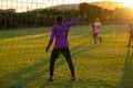 Rear view of african american goalkeeper with hand raised pointing while standing in front of net Royalty Free Stock Photo