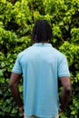Rear view of african american man with dreadlocks wearing pale blue polo shirt in garden Royalty Free Stock Photo