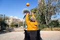 Rear view of African American man in a wheelchair throwing basketball in court playing alone. Royalty Free Stock Photo