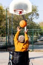 Rear view of African American man in a wheelchair throwing basketball in court. Royalty Free Stock Photo