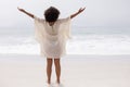 Woman standing with arms outstretched on beach in the sunshine Royalty Free Stock Photo