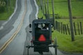 Rear View of an Amish Horse and Buggy traveling Down a Rural Road Royalty Free Stock Photo