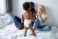 rear view on artistic child girl in diapers having fun with parents, mother clapping hands to her Royalty Free Stock Photo