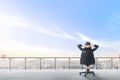 Rear view of asian business woman sitting on the office chair in modern terrace relax and looking at view on the city Royalty Free Stock Photo