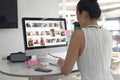 Female graphic designer drinking water while working on computer at desk in a modern office Royalty Free Stock Photo