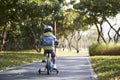 Rear view of asian little girl riding bike outdoos in park Royalty Free Stock Photo