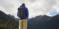 Rear view of asian traveler with backpack looking at mountains Royalty Free Stock Photo