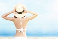 Rear view of Asian woman with bikini and hat relaxing Royalty Free Stock Photo