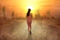 Rear view of Asian woman running on the street during a heatwave on the city with glowing sun background Royalty Free Stock Photo