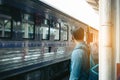 Rear view of asian young hipster man standing and waiting train Royalty Free Stock Photo