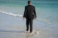 Rear view of back business man in suit in sea water at beach. Summer rest, business people concept. Business man remote Royalty Free Stock Photo