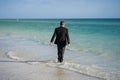 Rear view of back business man in suit in sea water at beach. Travel tourism and business concept. Crazy male office Royalty Free Stock Photo