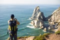 Rear view of backpacker taking photo of seascape