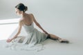 rear view of ballerina sitting in white dress