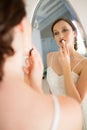 Rear view of beautiful bride applying lipstick reflecting on mirror