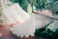 Rear view of beautiful girl in a white hammock in the garden at home. Young woman listening to music & dreaming of summer nature. Royalty Free Stock Photo