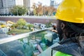 rear view of black male engineer in safety helmet supervising construction site from above
