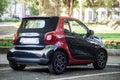 Rear view of black and red smart micro car parked in the street