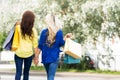 Rear view of blond and brunette walking holding hands