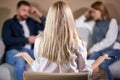 rear view on blond young psychologist woman looking at quarrelled couple sitting opposite Royalty Free Stock Photo
