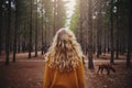 Blonde young woman with her dog in the forest Royalty Free Stock Photo