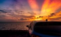 Rear view blue compact SUV car with sport and modern design parked on concrete road by the sea at sunset. Electric car technology Royalty Free Stock Photo