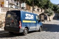 The rear view of a blue Opel Movano EcoFlex post office van of the SDA Posta Italiane delivering the parcels and packages