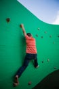 Rear view of boy climbing on green wall Royalty Free Stock Photo