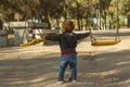 Rear view boy having fun with the swing at the playground Royalty Free Stock Photo