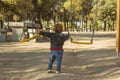 Rear view boy having fun with the swing at the playground Royalty Free Stock Photo